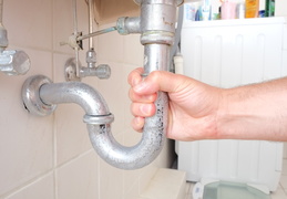 hand gripping drain pipe