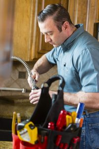 plumber-working-on-kitchen-sink-faucet