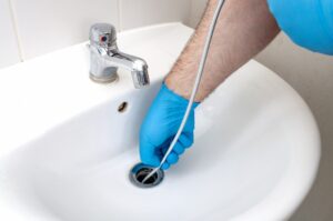 a-drain-snake-being-used-in-a-bathroom-sink